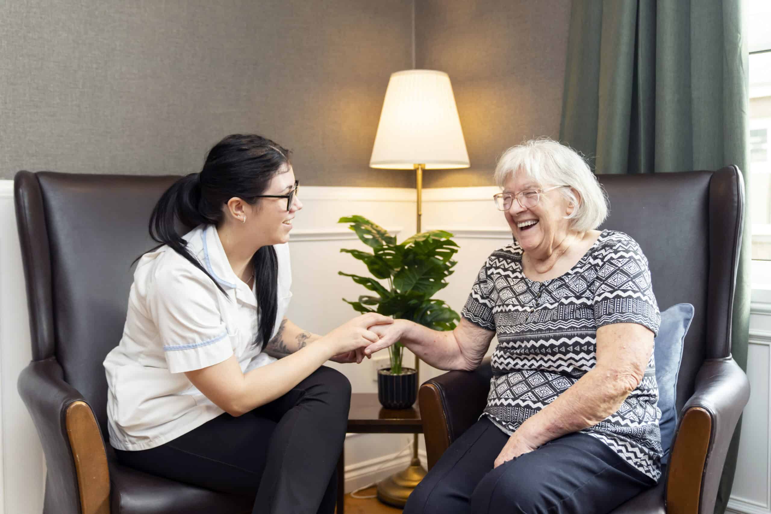 Caregiver and elderly woman sharing a joyful moment at Avonhaugh care home.