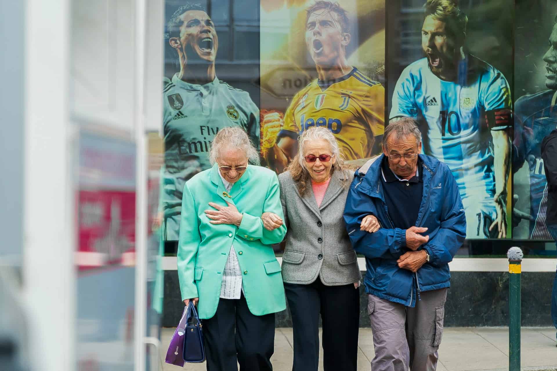 Elderly residents walking together outside Auchlochan care home, smiling and supporting each other.